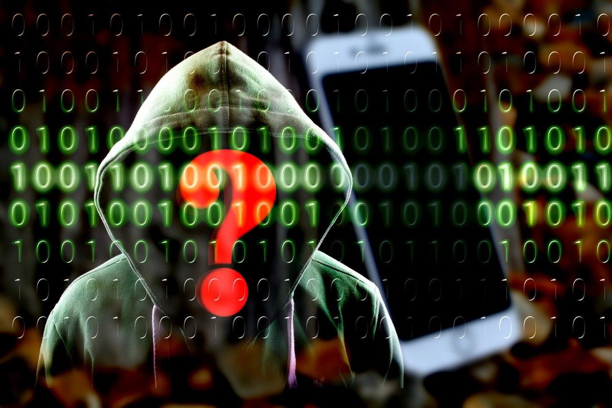 Image of a hooded figure holding a mobile device with red question mark.