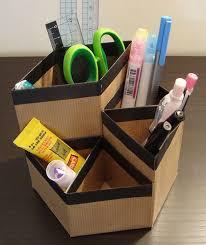 Cardboard desk organizer filled with assorted desk supplies.