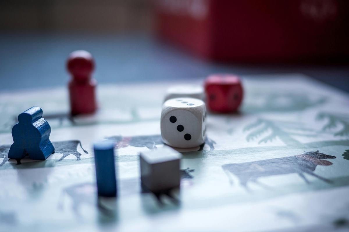 Game pieces and a die sitting on a board game